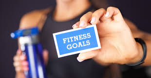 Person holding a card that says 'FITNESS GOALS'